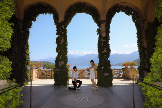 Golden-hour proposal at Villa del Balbianello with ivy-framed arches and Lake Como peninsula views — by Nadia Fraqair