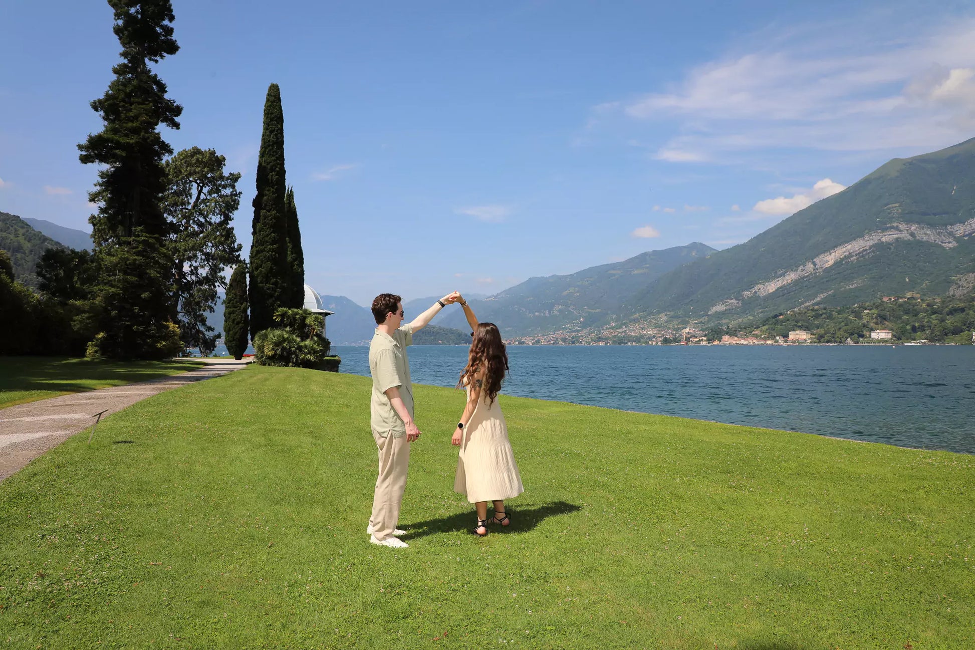 Romantic couple walking hand-in-hand by Lake Como during proposal video session