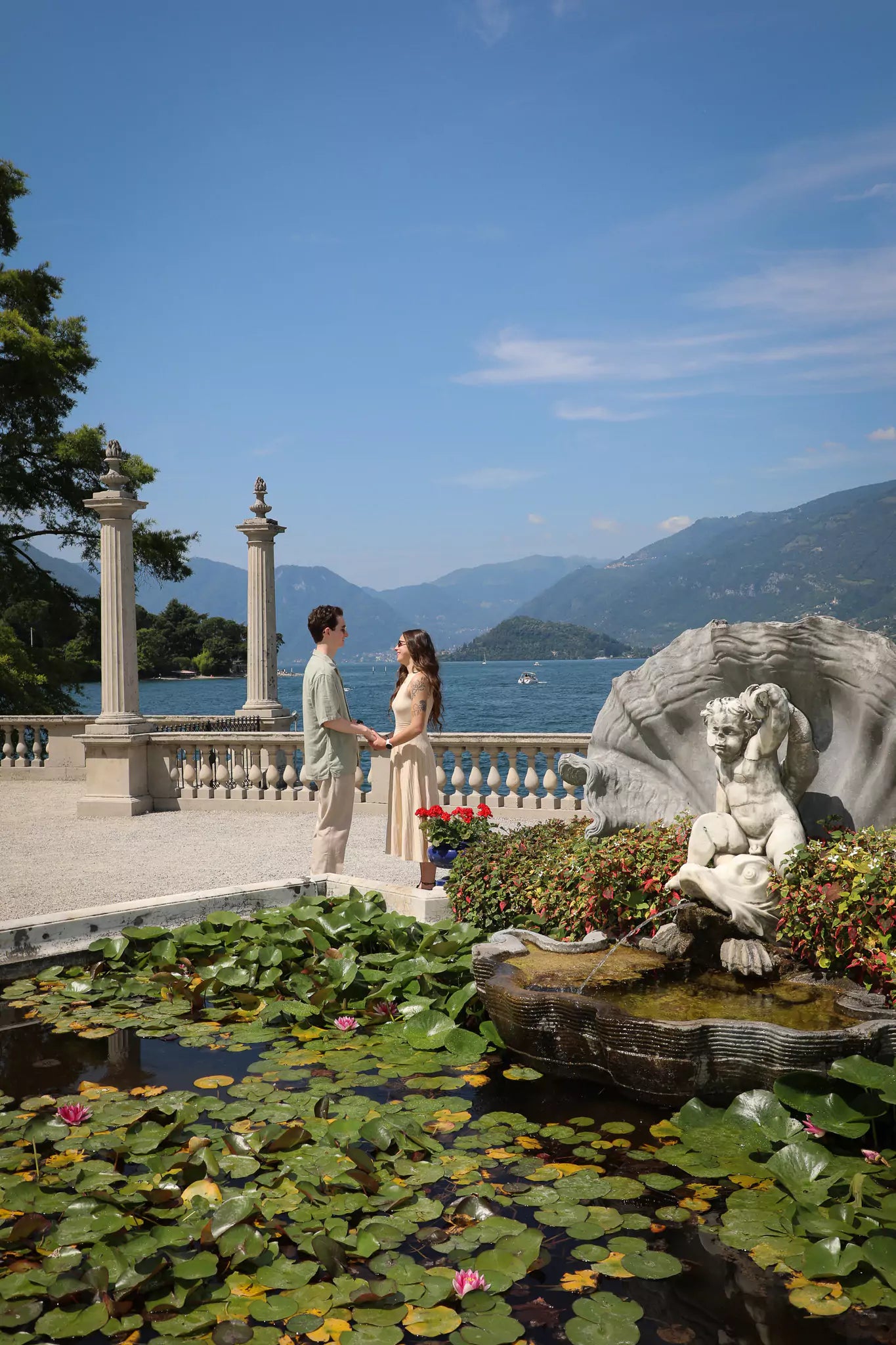 Couple admiring lakefront views after romantic proposal at Villa Melzi Gardens in Bellagio